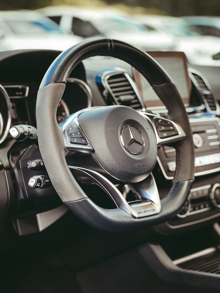 Close-up view of a luxury automobile's steering wheel in a modern car interior setting.